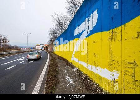 Teplice, Tschechische Republik. 17. März 2022. Der weiße Großbuchstabe Z, der an der Wand, die die Strecke durch die Stadt Teplice, Tschechische Republik, auslaminierte, in den Farben der ukrainischen Flagge gemalt wurde, abgebildet am 17. März 2022. In Russland wird beispielsweise der Buchstabe Z auf Autos, Häuser oder Kleidung gesetzt. Sie drücken ihre Unterstützung für die russischen Streitkräfte in der Ukraine aus. Quelle: Ondrej Hajek/CTK Photo/Alamy Live News Stockfoto