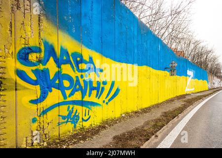 Teplice, Tschechische Republik. 17. März 2022. Der weiße Großbuchstabe Z, der an der Wand, die die Strecke durch die Stadt Teplice, Tschechische Republik, auslaminierte, in den Farben der ukrainischen Flagge gemalt wurde, abgebildet am 17. März 2022. In Russland wird beispielsweise der Buchstabe Z auf Autos, Häuser oder Kleidung gesetzt. Sie drücken ihre Unterstützung für die russischen Streitkräfte in der Ukraine aus. Die Inschrift auf der linken Seite liest der Ukraine Ruhm vor. Quelle: Ondrej Hajek/CTK Photo/Alamy Live News Stockfoto