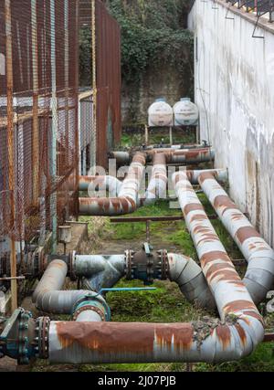 Alte rostige große Rohre und Ventile auf dem Boden Stockfoto