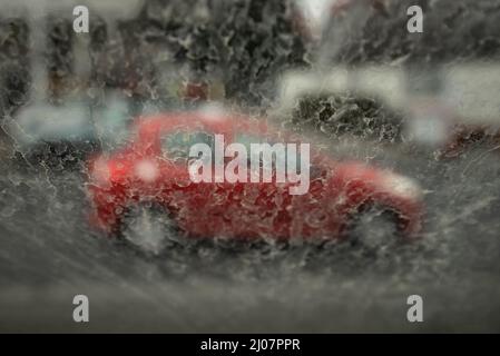 Ranstadt, Deutschland. 17. März 2022. Bei leichtem Regen setzt sich gelblicher Staub auf einer Windschutzscheibe ab. Südwestwinde hatten Wüstensand aus der Sahara in unsere Breiten geblasen, der jetzt vom Regen gebunden ist und sich auf Oberflächen niederlässt. Kredit: Frank Rumpenhorst/dpa/Alamy Live Nachrichten Stockfoto