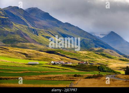 Die Berge überragen Oxnadalur mit einer Straße hinauf nach Oexnadalsheidi. Europa, Nordeuropa, Island Stockfoto