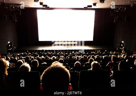 Menschen im Kino beim Film in der Schweiz. *** Lokale Bildunterschrift *** Kino, Film, Projektionsleinwand, Publikum, Menschen, Innen, Rückansicht, Große Gruppe Stockfoto