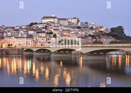 Ponte de Santa Clara Brücke über den Fluss Mondego in der Abenddämmerung und alte Stadtarchitektur mit Universitätsgebäude an der Spitze des Hügels in Coimbra Portugal. Stockfoto