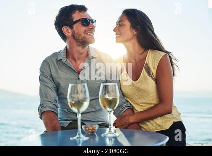 Gute Aussicht, toller Wein und bessere Gesellschaft. Eine kurze Aufnahme eines glücklichen Paares zu einem romantischen Date. Stockfoto
