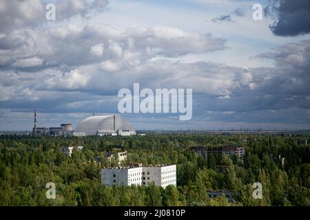 Pripjat, Ukraine. 4. September 2019. Eine Fernansicht der bogenförmigen New Safe Confinement-Struktur, die 2016 installiert wurde, um die Überreste der Reaktoreinheit Nr. 4 von Tschernobyl zu enthalten, die während der historischen Reaktorkatastrophe von Tschernobyl 1986 durch die Kernschmelze und Explosion des Reaktors zerstört wurde. Die Lage des Kernkraftwerks Tschernobyl ist nach Angaben der ukrainischen Regierung nach der Gefangennahme der russischen Streitkräfte weiterhin hoch gefährdet. Die russischen Streitkräfte stoppen wiederholt die Energieversorgung des Atomkraftwerks, mit dem der Kern der zerstörten Zahl 4 n abgekühlt wurde Stockfoto