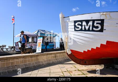 Brighton UK 17. March 2022 - Besucher genießen die Frühlingssonne an der Strandpromenade und am Strand von Brighton, da für Großbritannien in den nächsten Tagen warmes Wetter prognostiziert wird : Credit Simon Dack / Alamy Live News Stockfoto