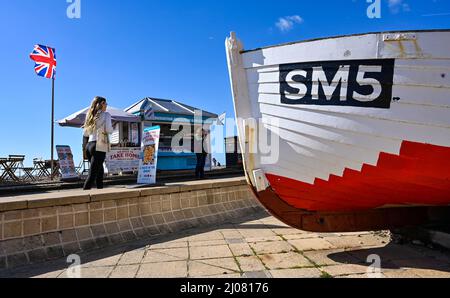 Brighton UK 17. March 2022 - Besucher genießen die Frühlingssonne an der Strandpromenade und am Strand von Brighton, da für Großbritannien in den nächsten Tagen warmes Wetter prognostiziert wird : Credit Simon Dack / Alamy Live News Stockfoto