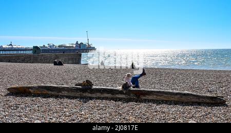 Brighton UK 17. March 2022 - Besucher genießen die Frühlingssonne an der Strandpromenade und am Strand von Brighton, da für Großbritannien in den nächsten Tagen warmes Wetter prognostiziert wird : Credit Simon Dack / Alamy Live News Stockfoto