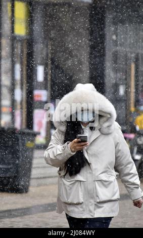 (220317) -- PEKING, 17. März 2022 (Xinhua) -- Ein Bürger läuft im Schnee in Peking, der Hauptstadt Chinas, 17. März 2022. Chinas meteorologische Behörden gaben am Donnerstag eine blaue Warnung für schweren Schnee im nördlichen Teil des Landes aus. (Xinhua/Li Xin) Stockfoto