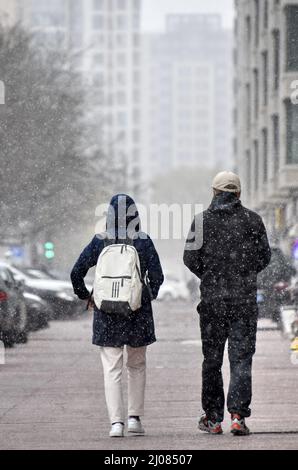 (220317) -- PEKING, 17. März 2022 (Xinhua) -- Menschen laufen im Schnee in Peking, der Hauptstadt Chinas, 17. März 2022. Chinas meteorologische Behörden gaben am Donnerstag eine blaue Warnung für schweren Schnee im nördlichen Teil des Landes aus. (Xinhua/Li Xin) Stockfoto