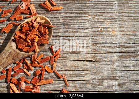 Stücke aus rotem Sandelholz auf einem Löffel auf einem hölzernen Hintergrund mit Kopierraum Stockfoto