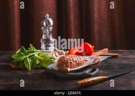 Handwerklicher Schinken aus putenfleisch, gekocht und geräuchert mit Zusatz von Hühnerfilet in einer Polyethylen-Vakuumverpackung. Stockfoto