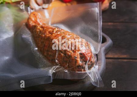 Handwerklicher Schinken aus putenfleisch, gekocht und geräuchert mit Zusatz von Hühnerfilet in einer Polyethylen-Vakuumverpackung. Stockfoto