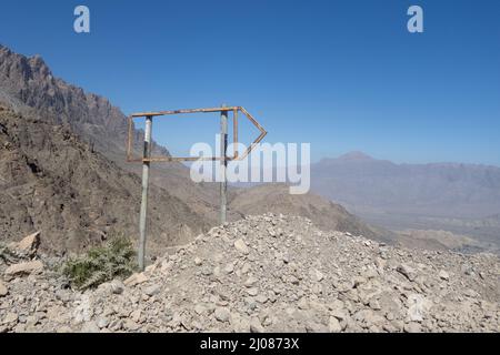 Schöne Aufnahme von Metall-Wegweiser ohne Schild auf sandigen und steinigen Berg Stockfoto