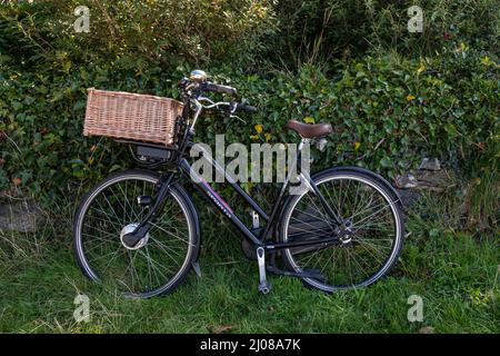Traditionelles Design-Fahrrad, das sich an einer alten Steinwand lehnt Stockfoto