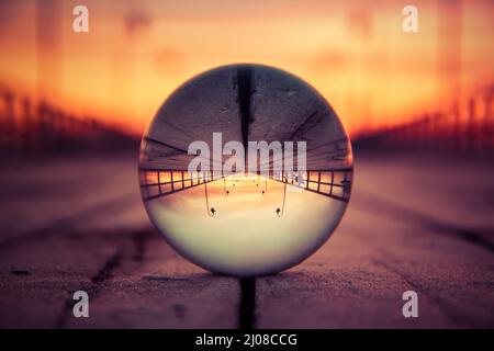 Abstraktes, farbenfrohes Urlaubskonzept. Spiegelung des Piers in Gdynia, Polen auf einer Glaskugel. Stockfoto