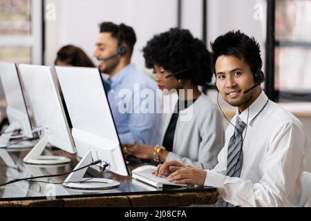 Positiver Kundendienstmitarbeiter mit Headset, der in Einem Call Center arbeitet Stockfoto