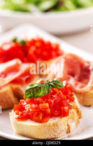 Italienische Vorspeise Bruschetta mit Parmaschinken auf einem Teller Stockfoto