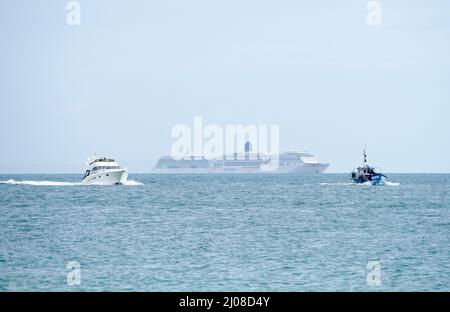 Zwei große Kreuzfahrtschiffe ankerten auf See mit einem Motorcruiser und einem kleinen Fischerboot im Vordergrund Stockfoto