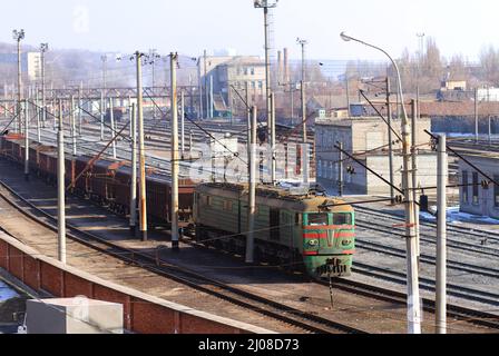 Die einzige Möglichkeit, in der Stadt zu reisen. Aufnahme eines Zuges auf den Gleisen mit Industrie im Hintergrund. Stockfoto