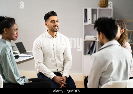 Junge multirassischen Tausendjährigen Freunde sitzen im Kreis, die Diskussion in der Gruppe Stockfoto