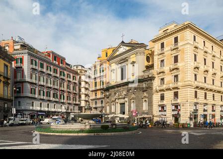 NEAPEL, ITALIEN - 23. DEZEMBER 2019: Normale Menschen gehen auf der Piazza Trieste E Trient, Blick auf die Straße mit der Fassade der Galleria Umberto Stockfoto