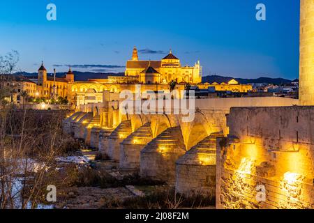 Römische Brücke über den Fluss Río Guadalquivir und die Mezquita - Catedral de Córdoba in der Abenddämmerung, Cordoba, Andalusien, Spanien | Roman b Stockfoto