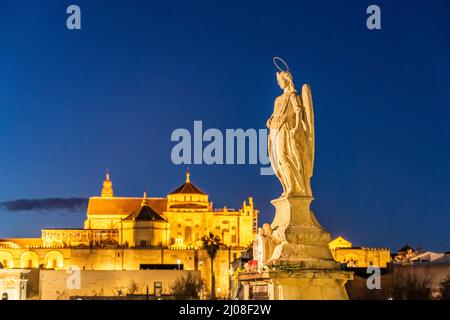 Statue des Erzengels Raphael auf der römischen Brücke und die Mezquita in der Abenddämmerung, Cordoba, Andalusien, Spanien | Statue des Erzengels Rap Stockfoto