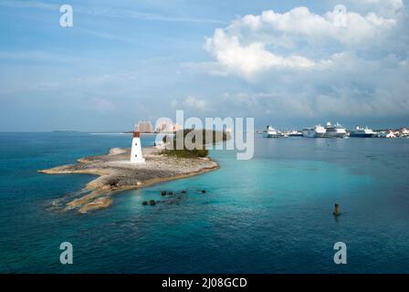 Die Luftaufnahme eines Leuchtturms auf einer Spitze von Paradise Island und von Kreuzfahrtschiffen, die im Hafen von Nassau (Bahamas) festgemacht sind. Stockfoto