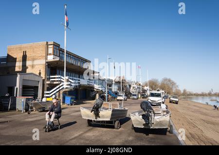 Ein älterer Mann, der auf einem Behindertenroller am Putney Embankment, Putney, London, England, Großbritannien, fährt Stockfoto