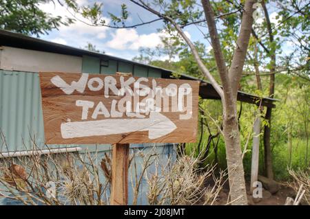 Ein Schild für die Werkstatt in Englisch und Spanisch Stockfoto