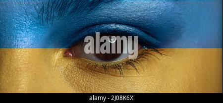 Gesicht der jungen Frau in den Farben der ukrainischen Flagge gemalt, Nahaufnahme Stockfoto