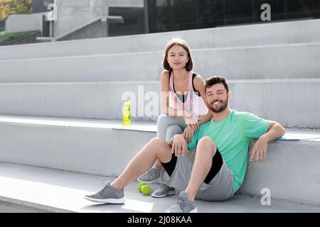 Junges Paar, das sich nach dem Training im Freien ausruhte Stockfoto