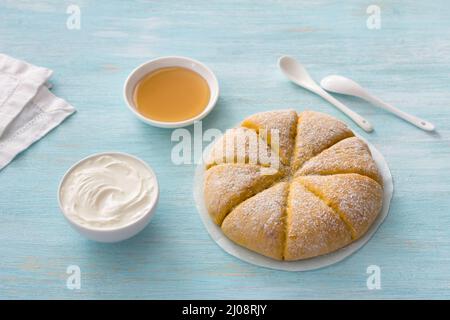 Frisch gebackene Karotten-Scones mit Creme auf hellblauem Hintergrund. Leckere hausgemachte Kuchen Stockfoto