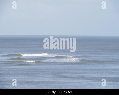 Ruhiges Meer, kleine brechende Wellen, schöner Hintergrund. Stockfoto