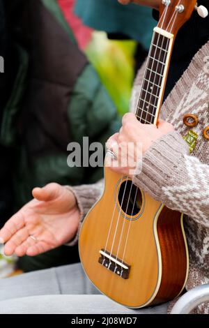 Ukulele in den Händen der Frau, sonniger Tag Stockfoto