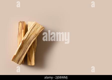 Palo Santo drei Stäbchen auf beigem Hintergrund. Minimalistischer Style. Rituelle Reinigung, Meditation, spirituelle Praxis. Blick von oben. Stockfoto
