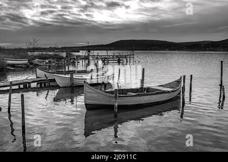 Der ruhige Nachmittag auf einem See mit einem hölzernen Pier und Booten. Stockfoto