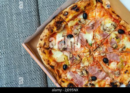 Pizza Capricciosa. Pizza mit Schinken, Oliven, Pilzen und Artischocken. Stockfoto