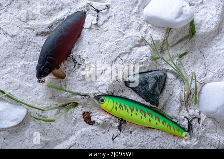 Verschiedene Köder zum Angeln im Sand. Wobbler zum Fang von Raubfischen. Harte Köder im Sand. Stockfoto