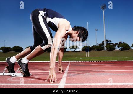 Der Prozess der Vorbereitung. Ein junger Läufer, der sich auf ein Rennen vorbereitet. Stockfoto