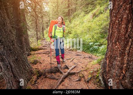 Ein Touristen- oder Wandermädchen spaziert durch einen wunderschönen und grandiosen Wald entlang eines Pfades in Kanada Stockfoto