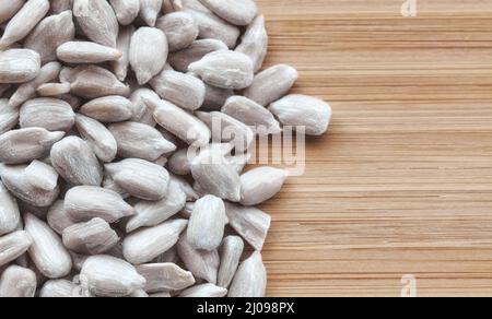 Nahaufnahme von geschälten Sonnenblumenkernen auf einem hölzernen Hintergrund, selektiver Fokus. Stockfoto