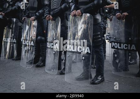 Weibliche Polizisten bereiten sich darauf vor, feministische Demonstranten für den internationalen Frauentag zu verdrängen Stockfoto