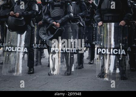 Weibliche Polizisten bereiten sich darauf vor, feministische Demonstranten für den internationalen Frauentag zu verdrängen Stockfoto