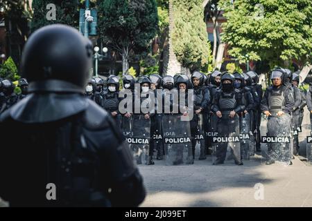 Weibliche Polizisten bereiten sich darauf vor, feministische Demonstranten für den internationalen Frauentag zu verdrängen Stockfoto