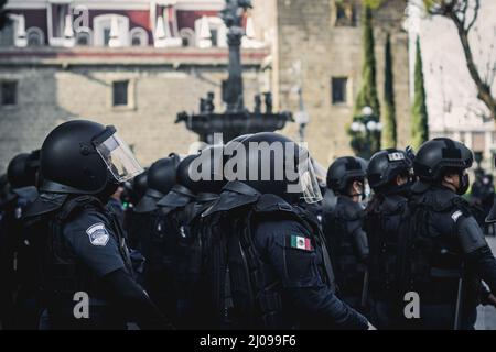 Weibliche Polizisten bereiten sich darauf vor, feministische Demonstranten für den internationalen Frauentag zu verdrängen Stockfoto