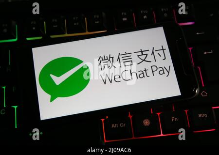 Viersen, Deutschland - März 9. 2022: Nahaufnahme des Handybildschirms mit Logo-Schriftzug von wechat Pay auf der Computertastatur Stockfoto