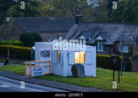 Wahllokal am Wahltag geöffnet (temporäre Metallhütte, Schilder) in ländlicher Gemeinde - Village Green, Burley Woodhead, West Yorkshire, England, Großbritannien. Stockfoto