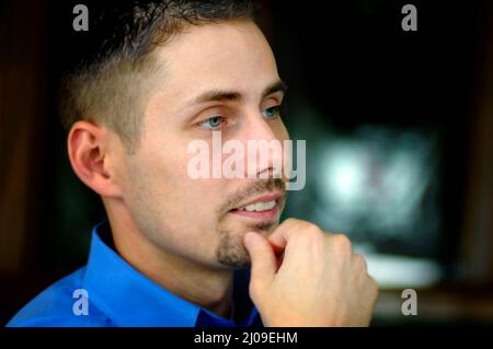 Gesicht von 30s Mann mit Spitzbart und blauen Augen bei einem Familientreffen mit Verwandten und kurzen Haaren Stockfoto
